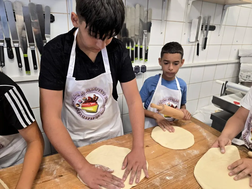 Gyerekek pizzatésztát nyújtanak Alex műhelyében