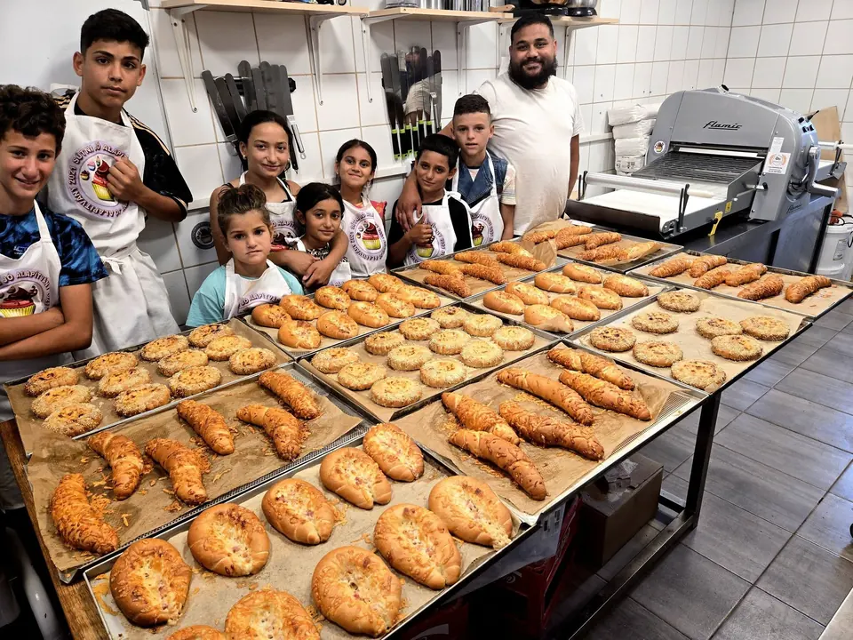 Gyerekek több tepsi elkészült péksüteménnyel